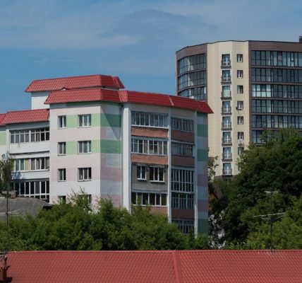 a building with a red roof next to trees