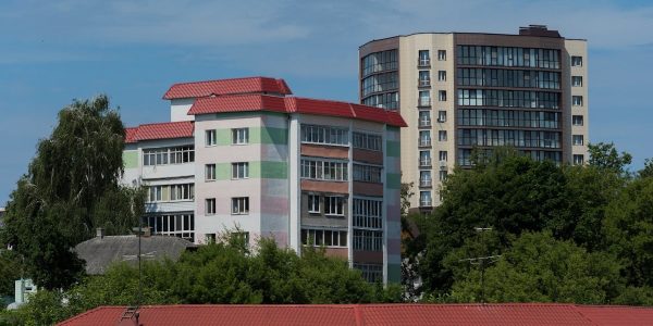 a building with a red roof next to trees