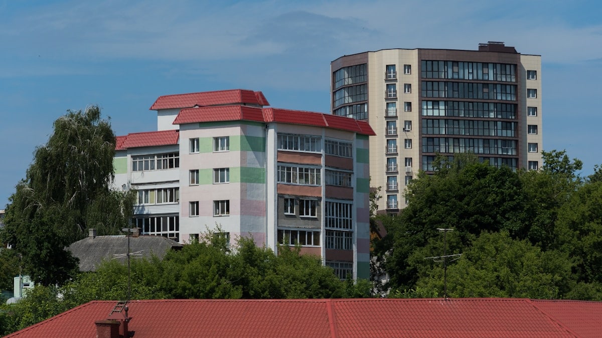 a building with a red roof next to trees